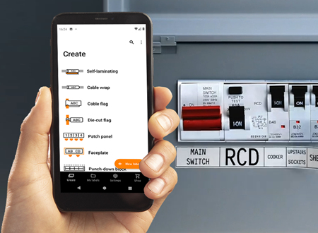 Pro Label Tool app vist på en smarttelefon og et el-panel i bakgrunnen