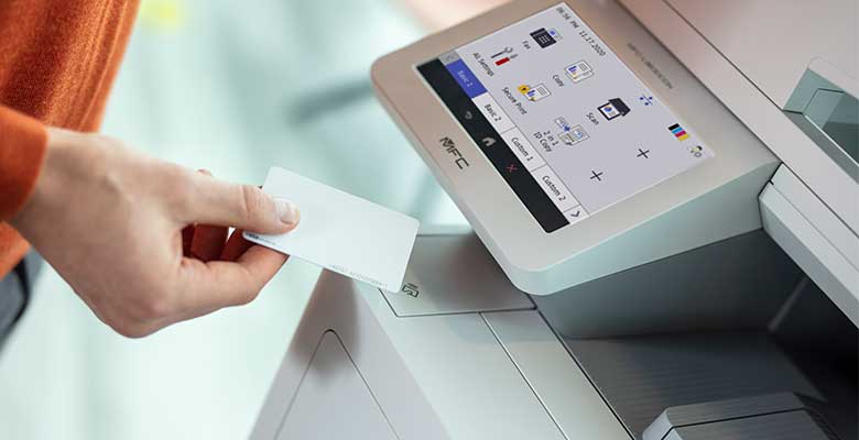 Person som holder NFC-kort ved siden av skriveren med skjerm