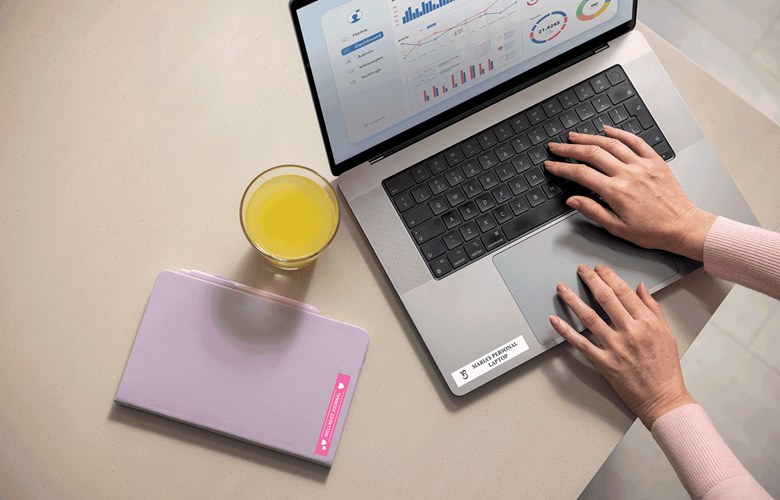 Laptop og notatblokk merket av hjemmearbeideren med Btag-fargede etiketter 