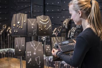 Butikkansatt merker smykker med prisetiketter