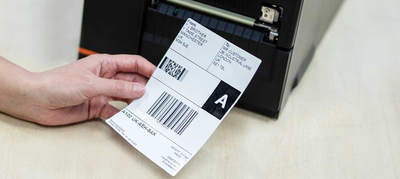 Fraktetikett som skrives ut fra en industriell mobil skriver i Brother TJ-serien på et lager